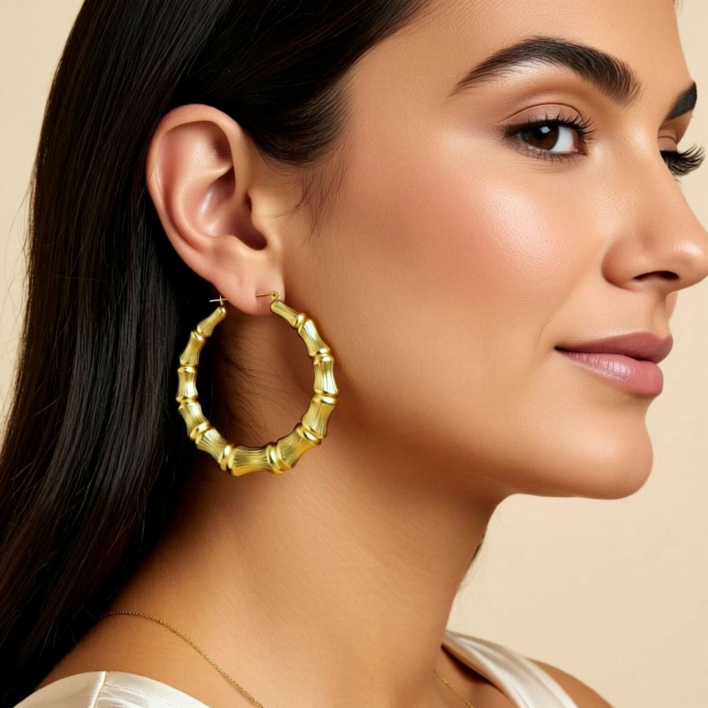 Woman wearing gold hoop earrings with a neutral background